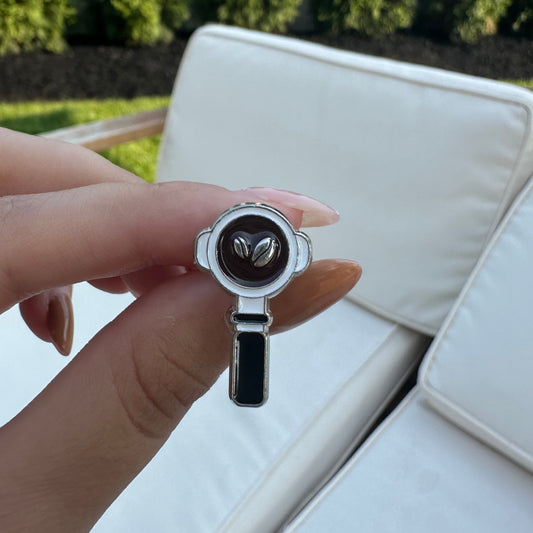 Hand holding a small round object with a blurred background